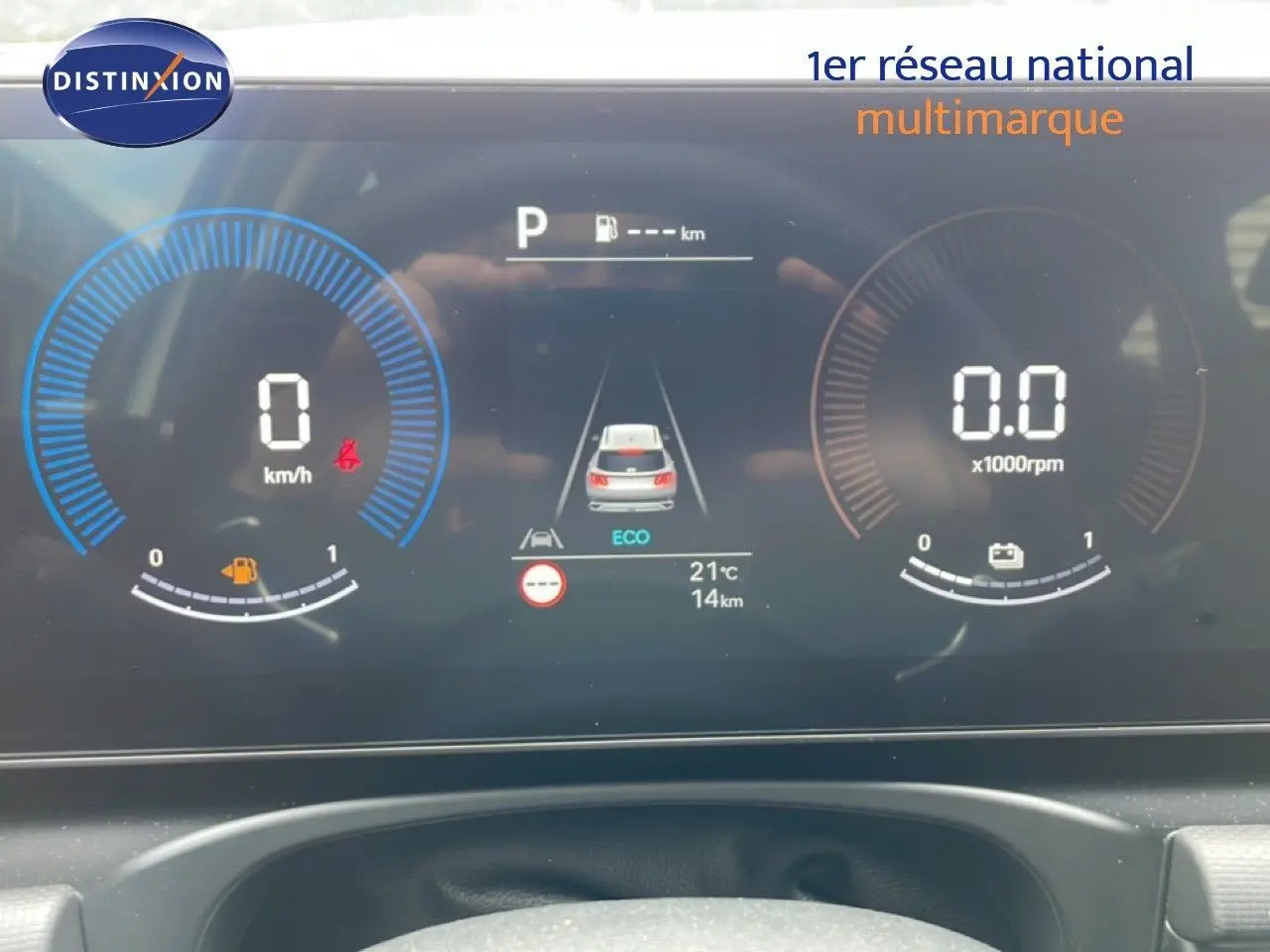 Tableau de bord numérique du Hyundai Tucson blanc, affichage vitesse, régime et mode éco en vue frontale rapprochée.