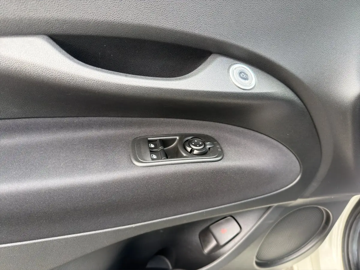 Détail de la porte côté conducteur de la FIAT 500 blanche 2023 avec commandes de vitres et rétroviseurs électriques.
