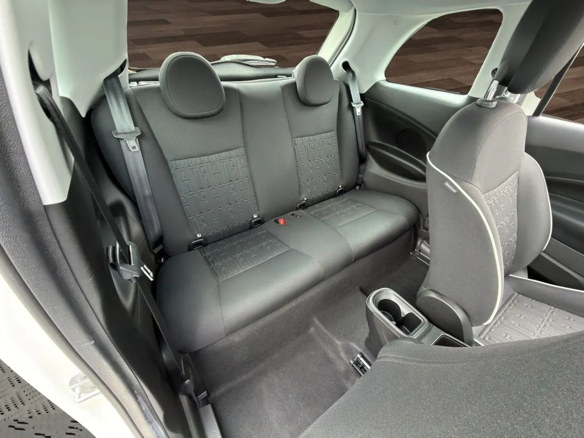 Vue intérieure arrière côté gauche de la banquette noire avec motifs FIAT dans une FIAT 500 blanche électrique 2023.