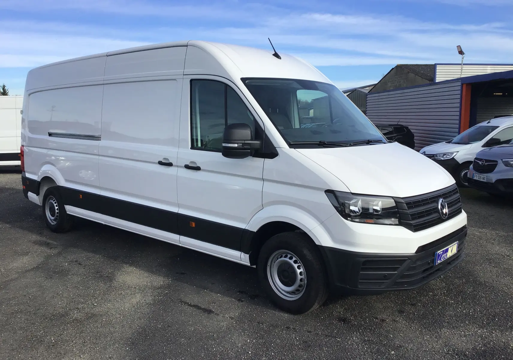 Volkswagen Crafter blanc vu en 3/4 avant droit, fourgon utilitaire avec calandre noire et jantes acier simples.