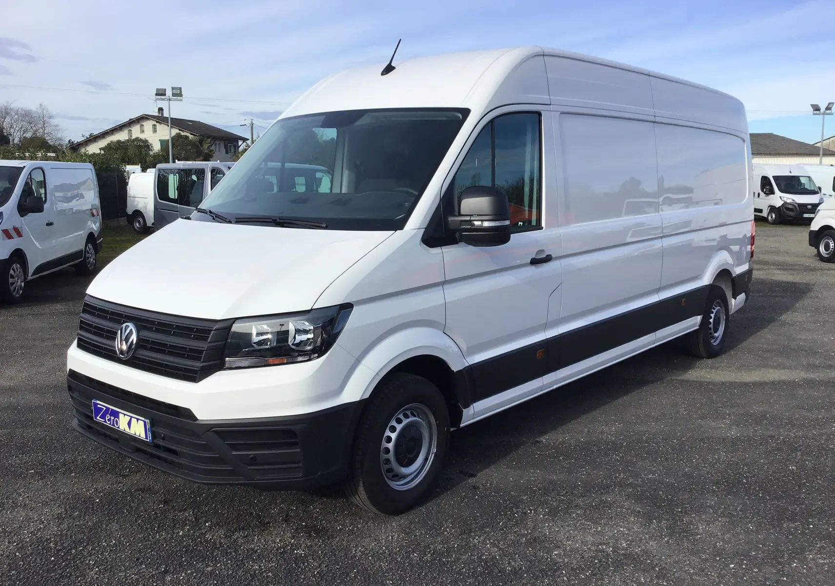 Volkswagen Crafter blanc en vue 3/4 avant droit, fourgon utilitaire avec calandre noire et jantes acier simples.