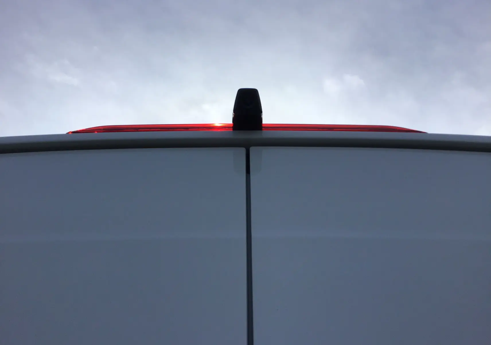 Vue rapprochée de l'arrière blanc du Volkswagen Crafter Fourgon 2024 avec caméra de recul sur la porte haute.