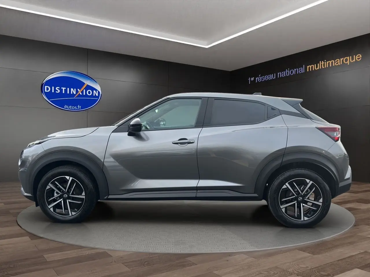 Profil côté gauche du Nissan Juke Full Hybrid 143 N-Connecta gris squale avec jantes alliage 17 pouces en showroom.