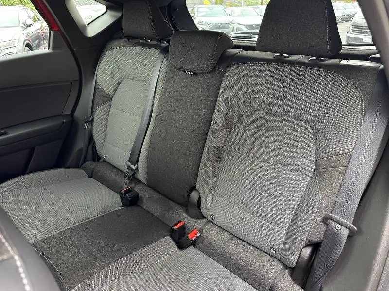 Vue intérieure sur les sièges arrière gris du Renault Captur 1.6 E-Tech hybride, avec ceintures de sécurité et appuie-têtes visibles.