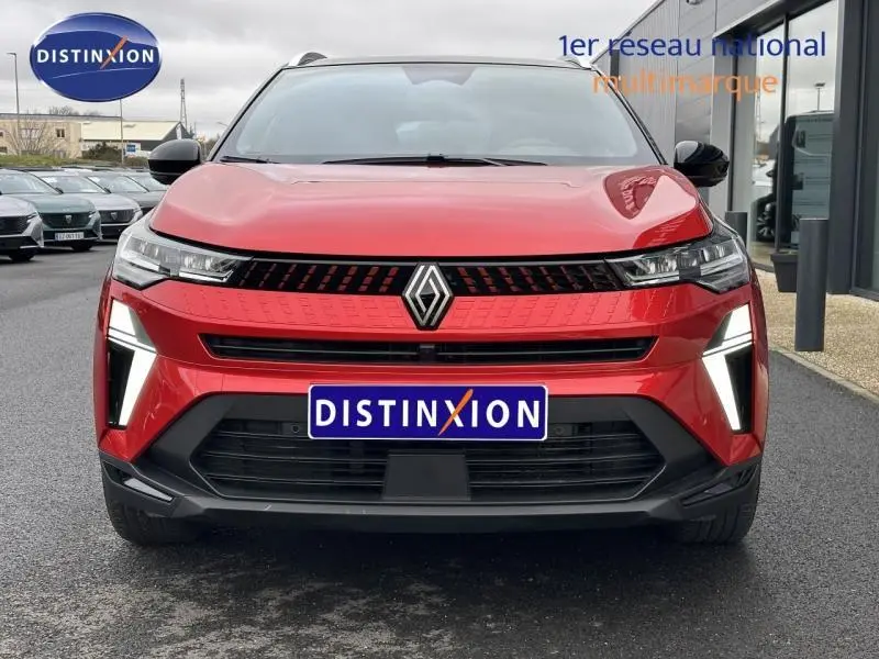 Vue de face du Renault Captur 2025 rouge flamme avec signature lumineuse LED distinctive et calandre moderne.