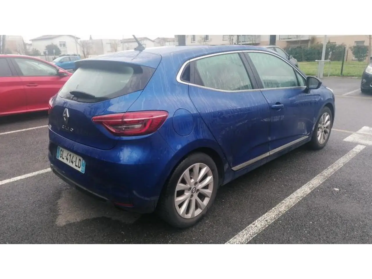 Renault Clio 1.0 Tce Intens bleu Iron vue 3/4 arrière droit, jantes alliage et feux arrière distinctifs.