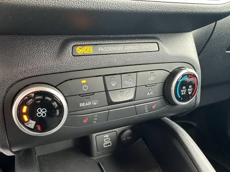 Vue rapprochée de la console de climatisation du Ford Kuga 2024 avec commandes tactiles et voyants allumés.