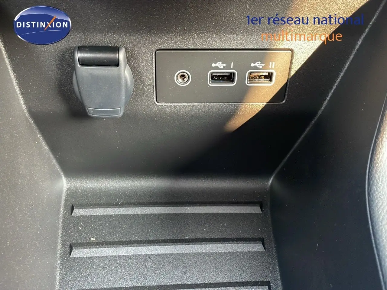 Détail intérieur montrant deux ports USB et une prise 12V sur la console centrale d'une Renault Clio gris schiste.