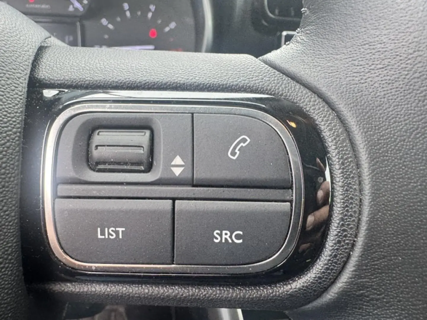 Gros plan sur les commandes audio au volant cuir du Citroën C3 Aircross 2024, côté gauche.