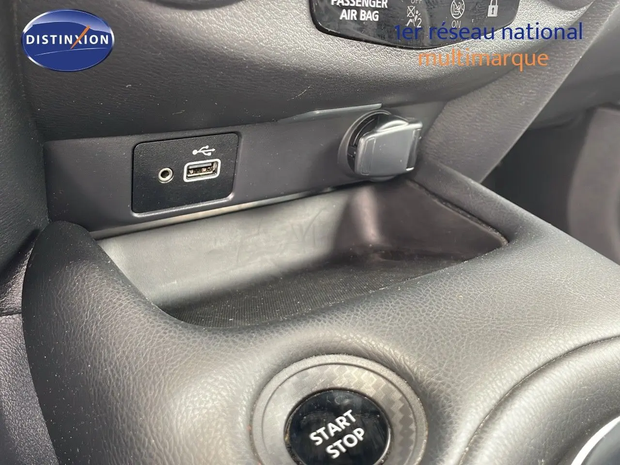 Gros plan sur la console centrale du Nissan Juke Hybrid 2023, montrant le bouton Start Stop et les ports USB et allume-cigare.