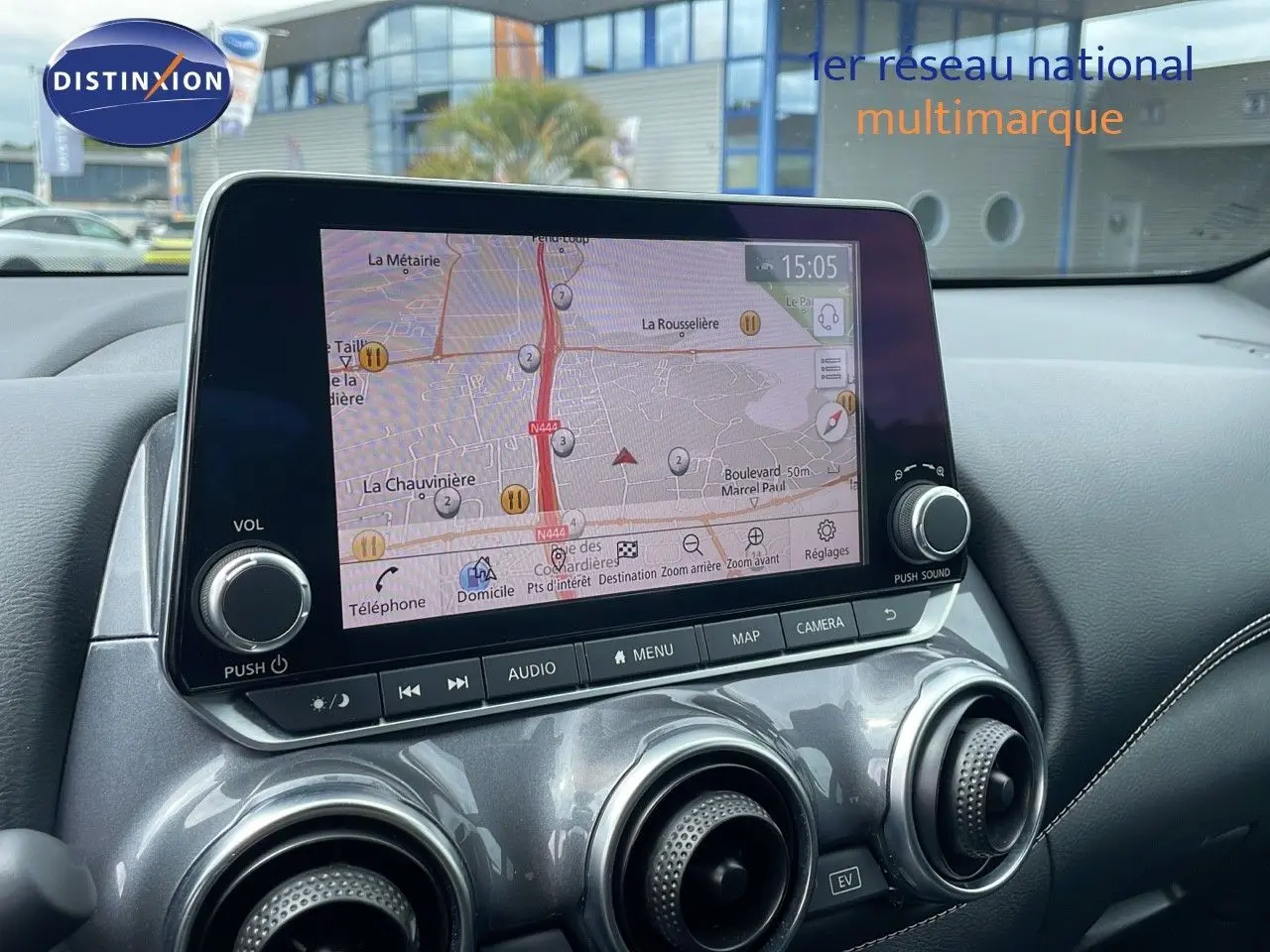 Vue rapprochée de l'écran tactile central et des aérateurs gris perle métallisé du tableau de bord du Nissan Juke Hybrid 2023.