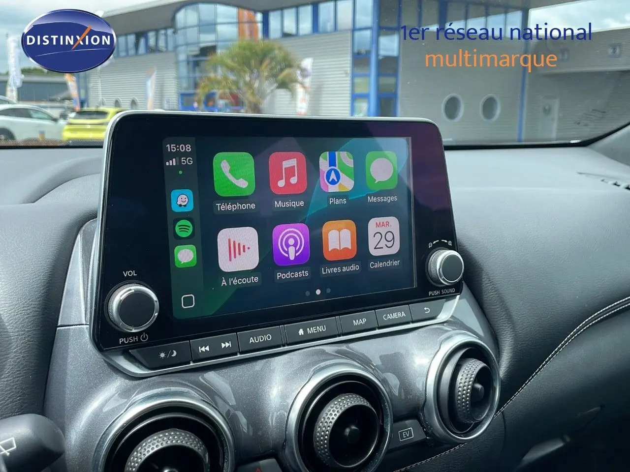 Écran tactile central avec Apple CarPlay dans l'habitacle d'un Nissan Juke Hybrid gris perle 2023.