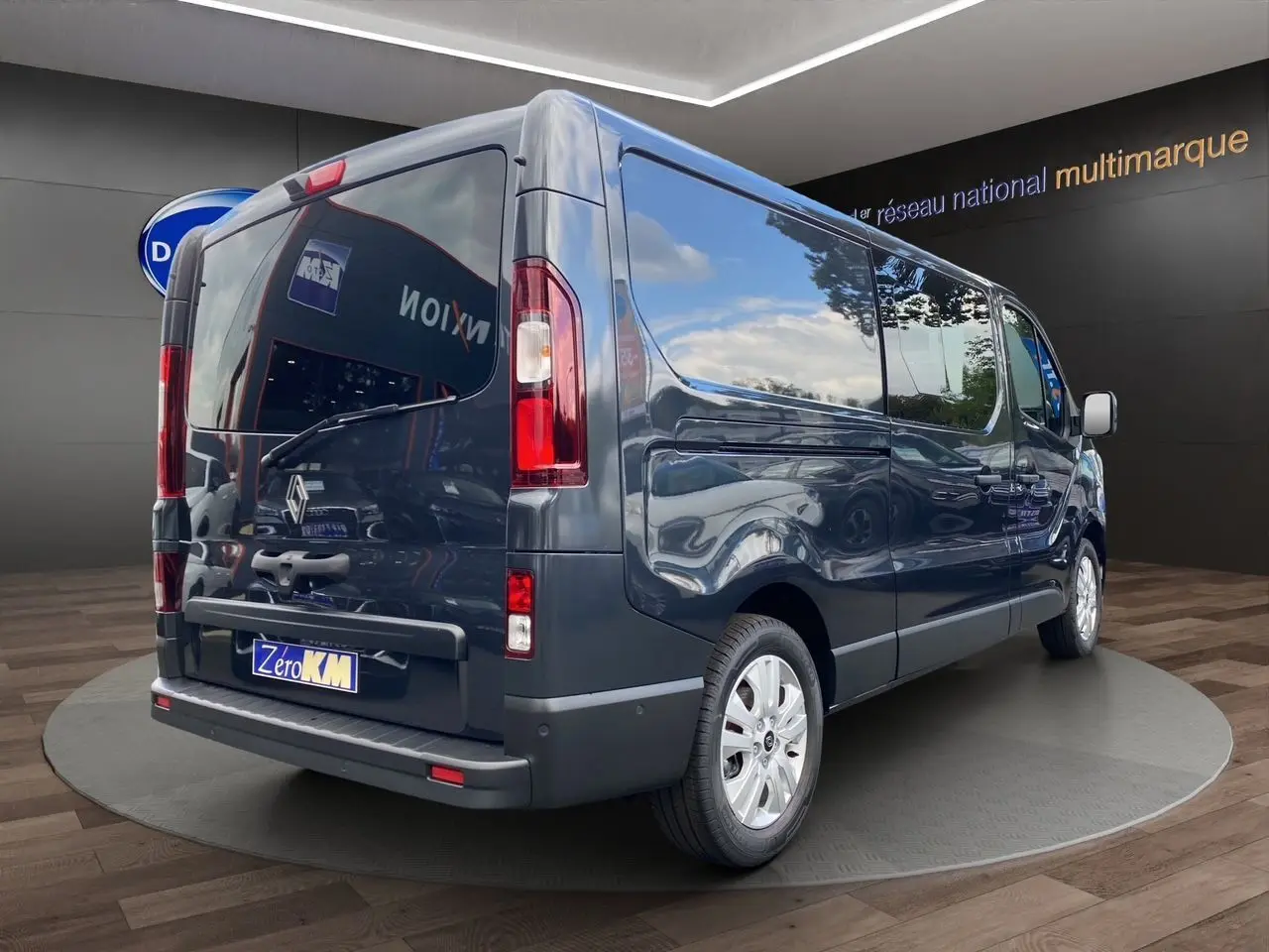 Vue 3/4 arrière droit d’un Renault Trafic cabine approfondie gris comète avec hayon vitré et jantes alu 17 pouces.