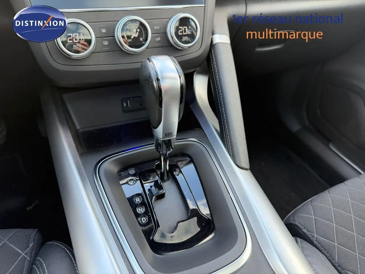 Gros plan sur la console centrale du Renault Kadjar blanc nacré, mettant en valeur le levier de vitesse automatique et les commandes de climatisation.