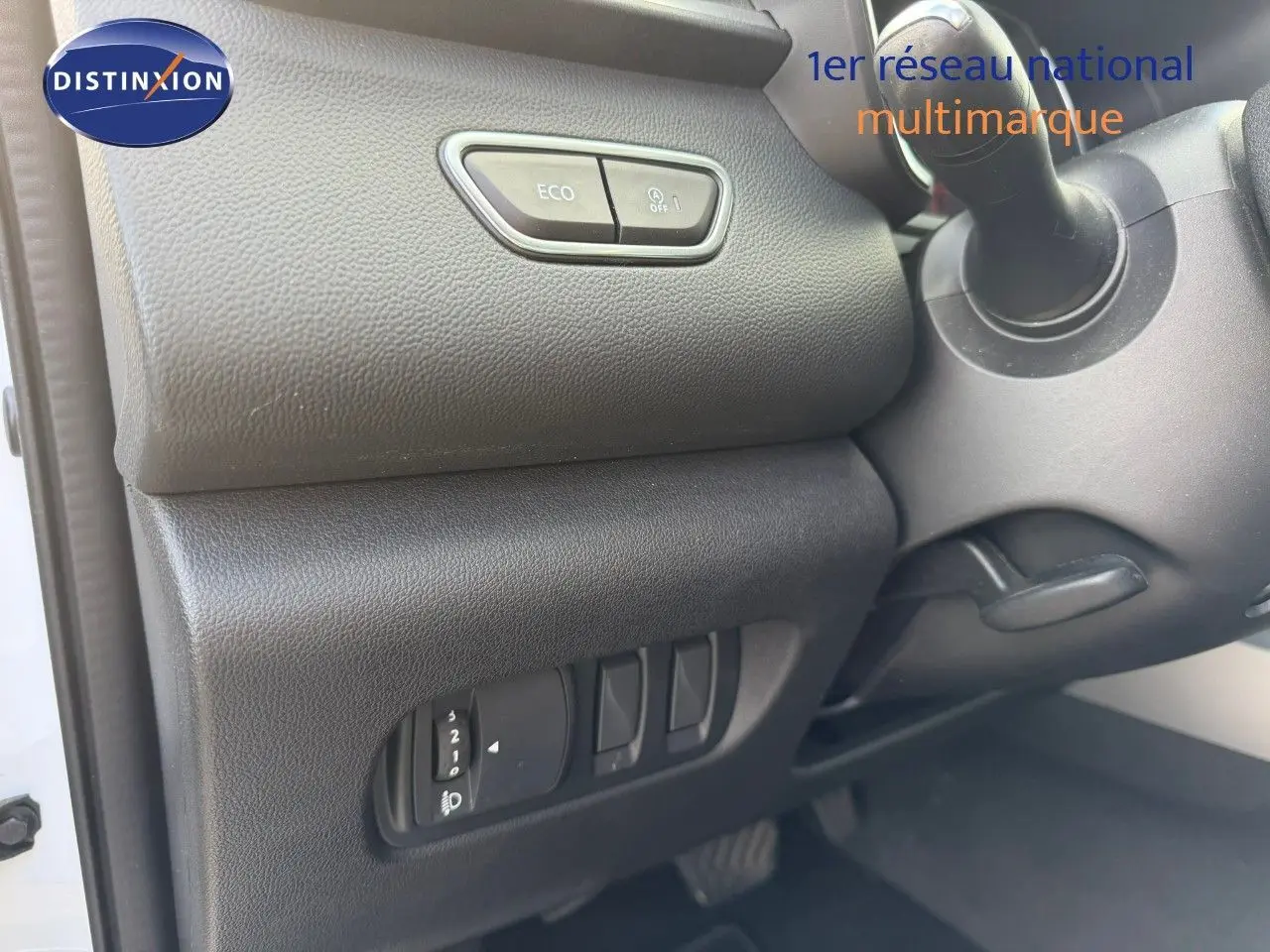 Vue intérieure côté gauche du tableau de bord du Renault Kadjar blanc nacré, avec boutons de commande ECO et réglage des phares.