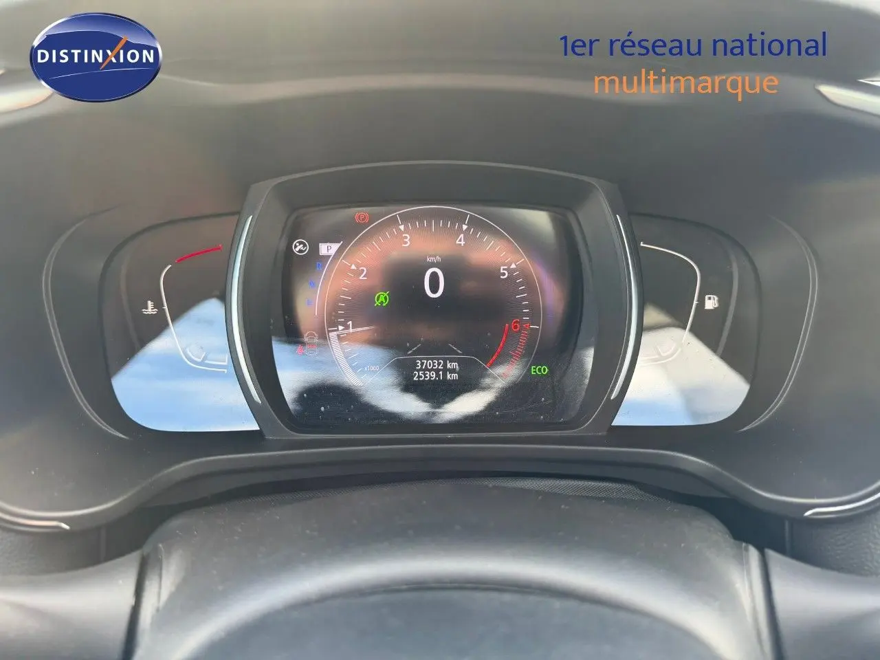 Vue rapprochée du tableau de bord numérique du Renault Kadjar blanc nacré, affichant le compteur et les voyants.
