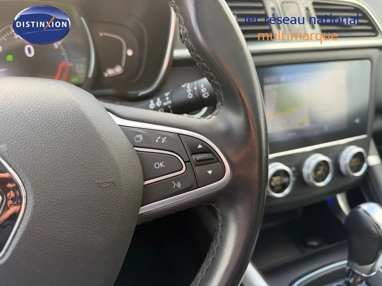 Gros plan sur le volant en cuir noir et la console centrale avec écran tactile du Renault Kadjar blanc nacré 2019.