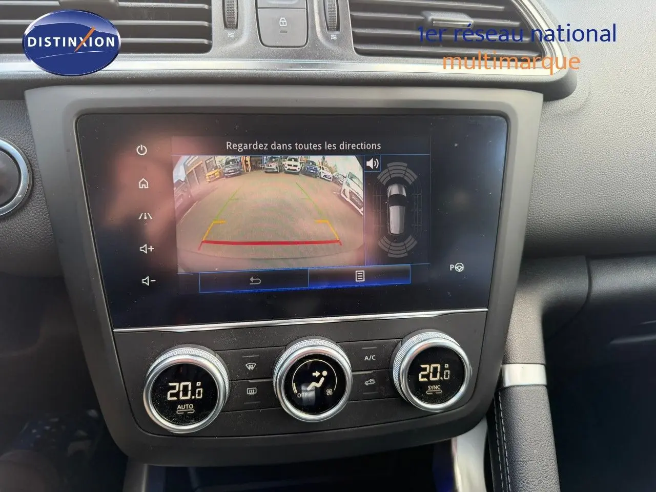 Vue rapprochée de l’écran multimédia et des commandes de climatisation du Renault Kadjar blanc nacré, affichant la caméra de recul.