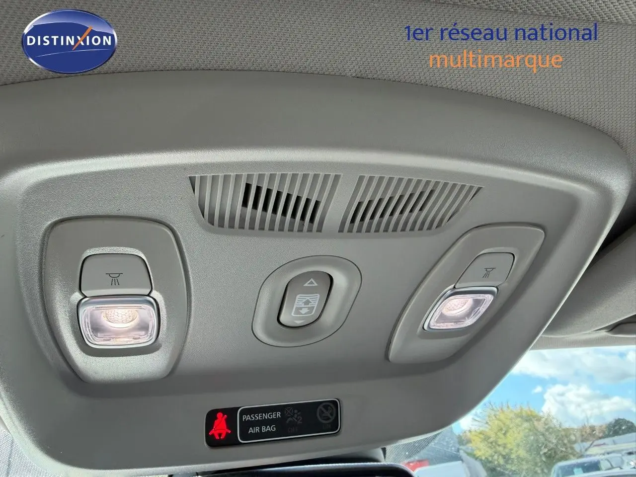 Plafonnier intérieur avec éclairages de lecture allumés et commande d'ouverture de toit ouvrant dans un Renault Kadjar blanc nacré.