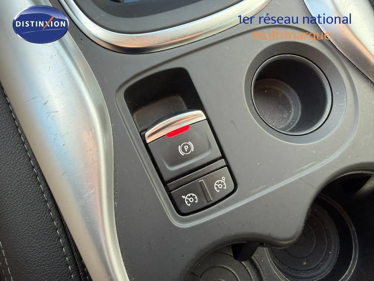 Gros plan sur la console centrale du Renault Kadjar blanc nacré, montrant le frein à main électronique et commandes de régulateur.