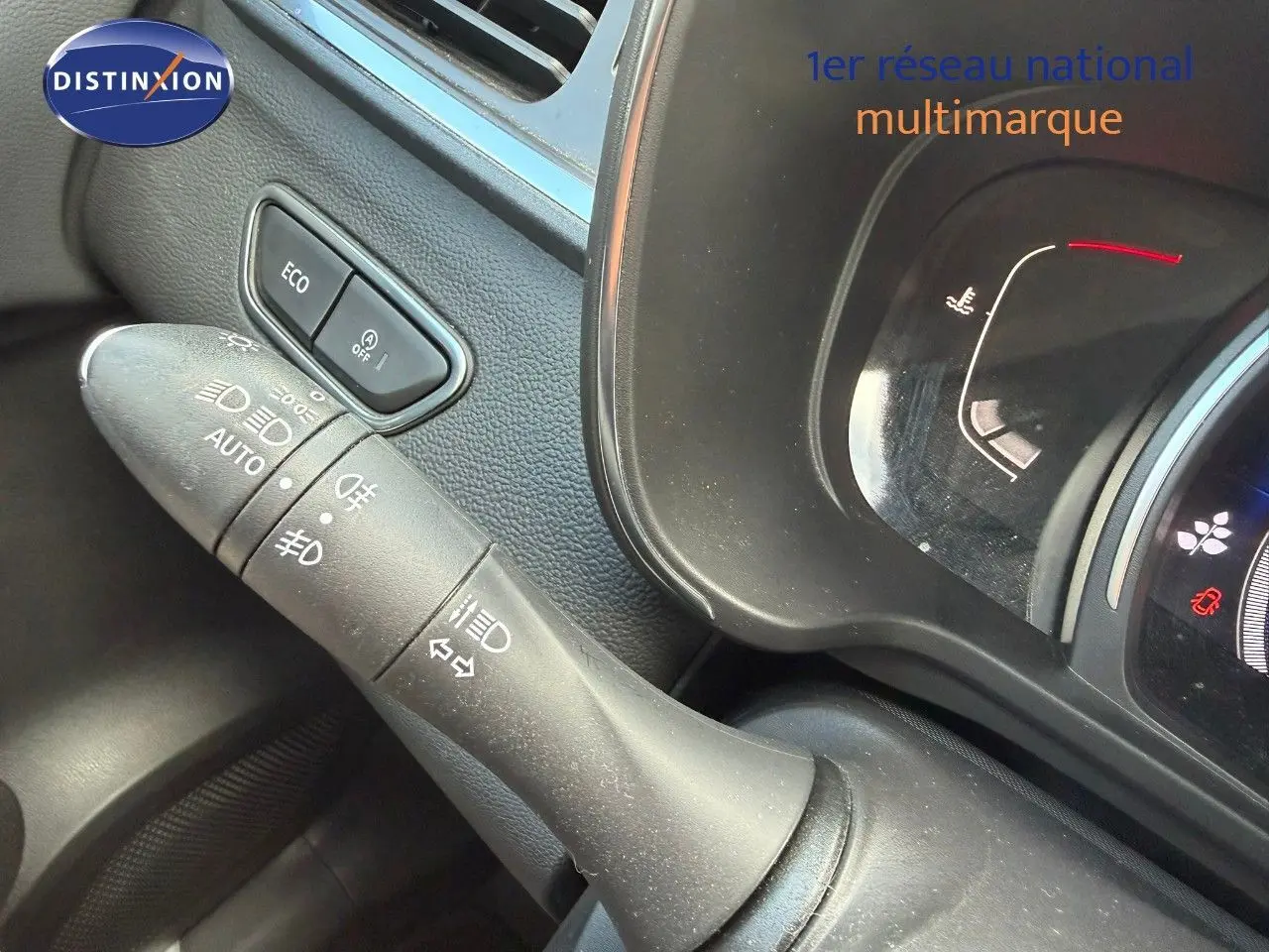 Gros plan sur la commande des phares et le bouton ECO à gauche du tableau de bord du Renault Kadjar blanc nacré.