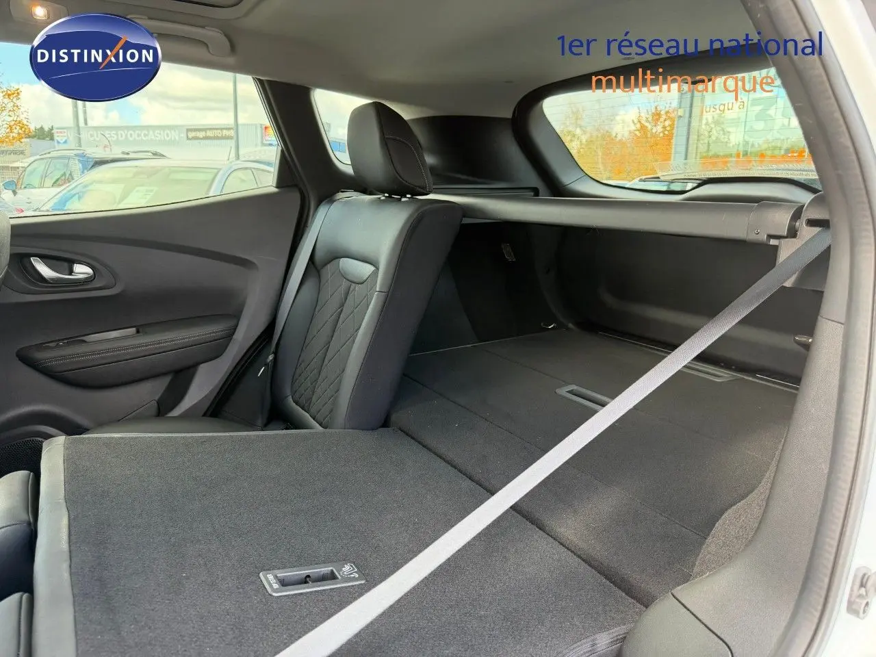 Vue intérieure arrière droite du Renault Kadjar blanc nacré, siège rabattable et espace de coffre étendu.