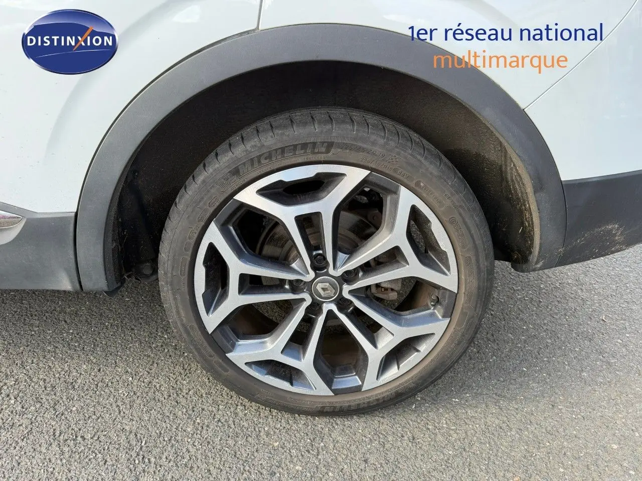 Gros plan sur la roue avant droite du Renault Kadjar blanc nacré avec jante alliage 19 pouces bicolore.