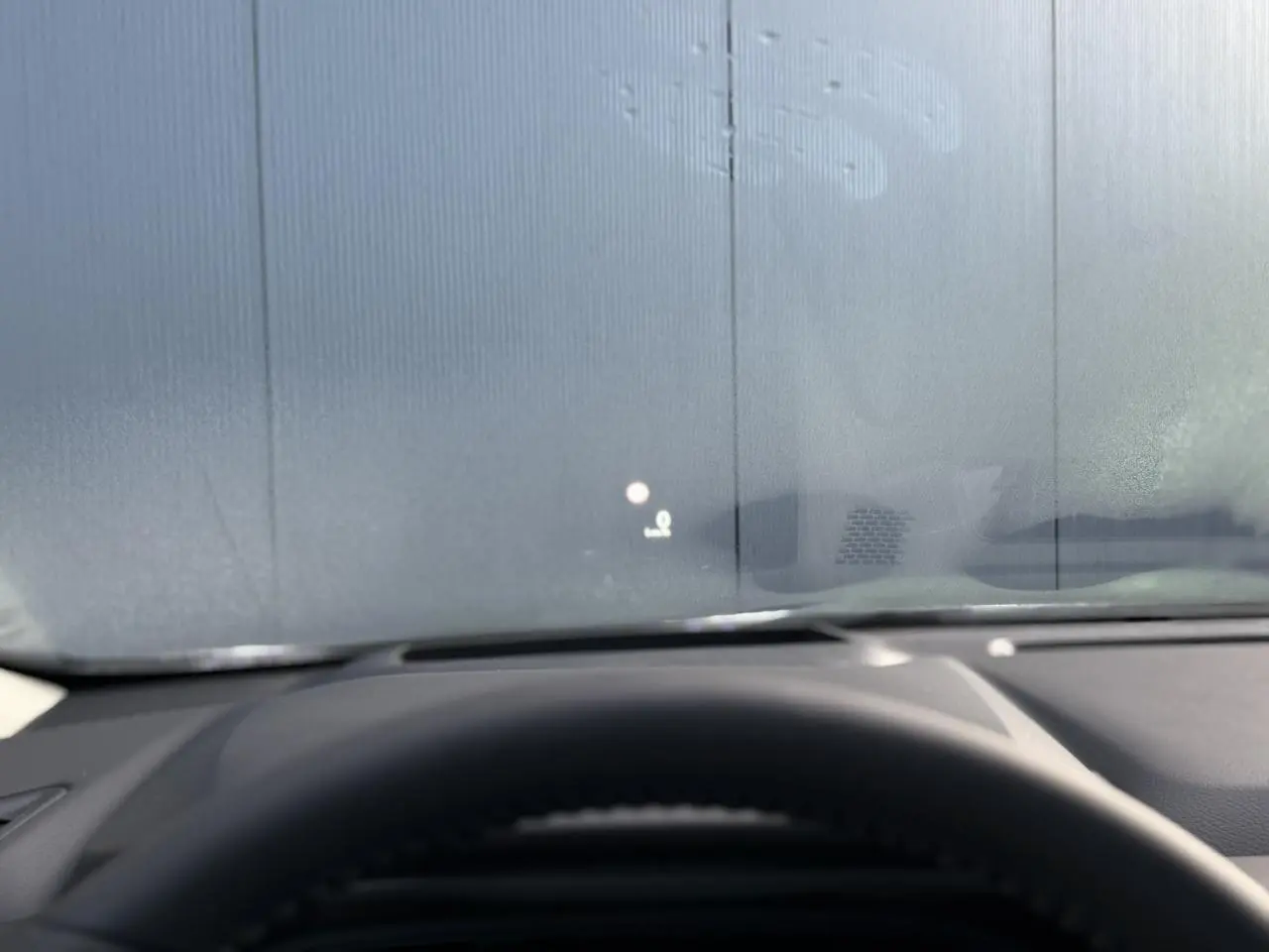 Vue intérieure du tableau de bord du Nissan Qashqai blanc nacré 2025 avec affichage tête haute sur pare-brise.