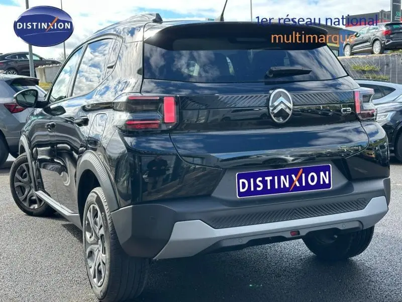 Vue 3/4 arrière d'une Citroën C3 1.2 Turbo noire Perla Nera avec feux arrière LED et jantes alu visibles.