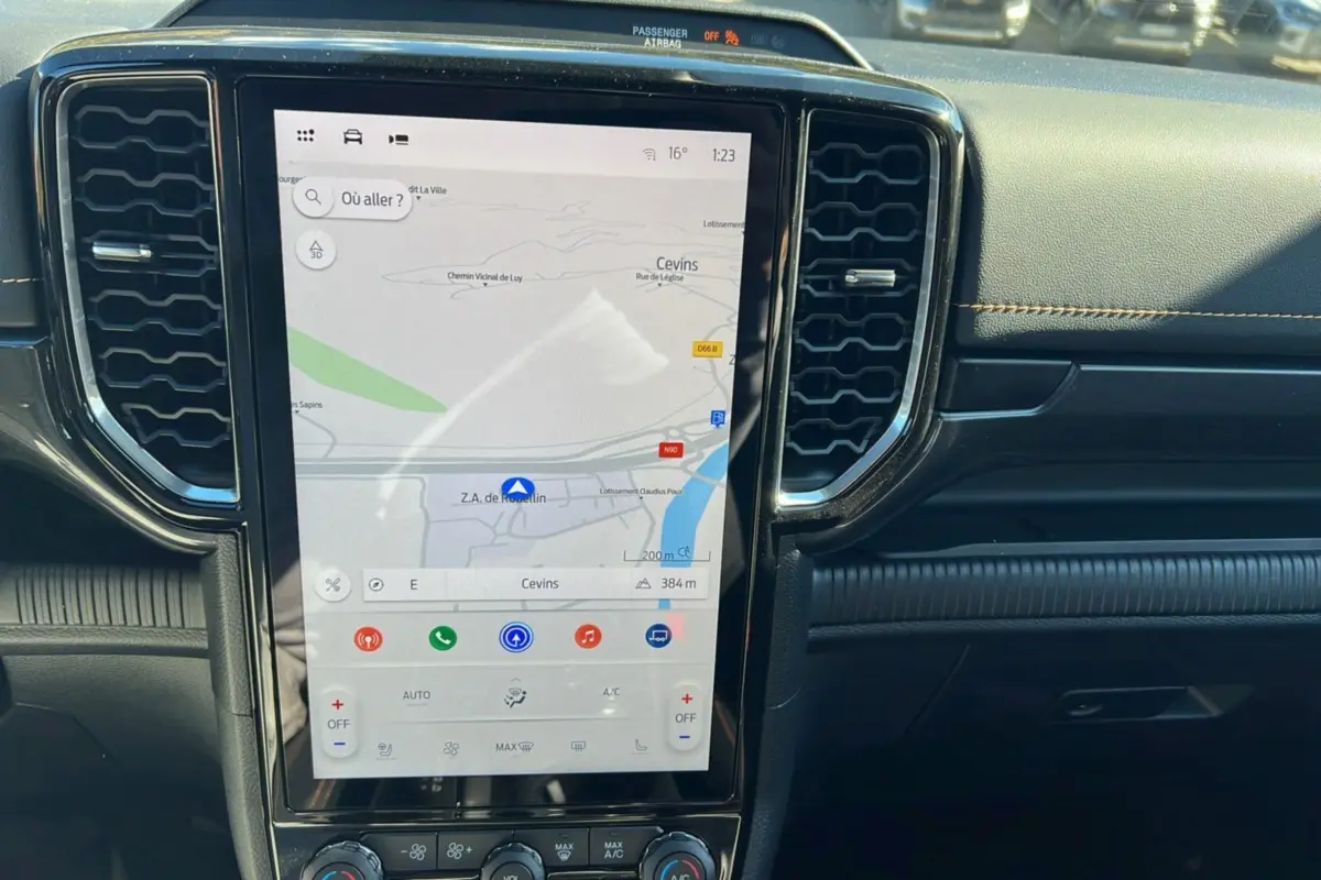 Écran tactile vertical du Ford Ranger 2025 avec navigation, entouré de grilles d’aération noires et tableau de bord noir.