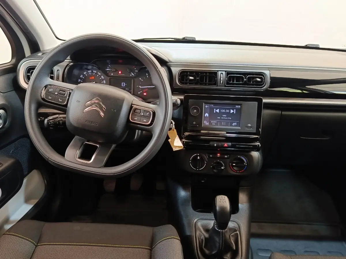 Vue intérieure avant du tableau de bord de la Citroën C3 blanche, volant multifonctions et écran tactile central visible.