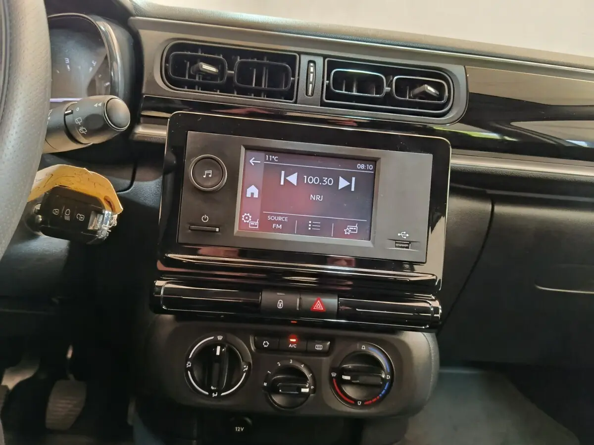 Vue rapprochée de l’intérieur de la Citroën C3 2021, tableau de bord avec écran tactile et commandes de climatisation.