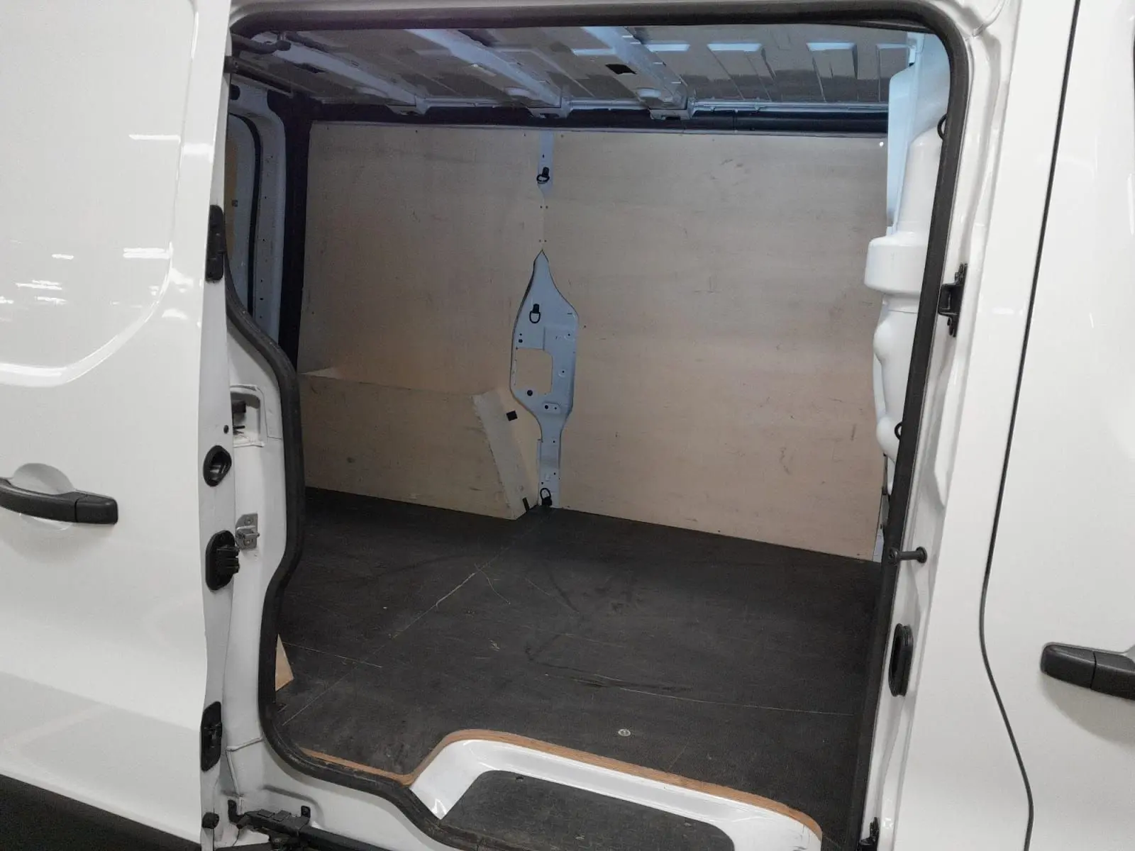 Vue intérieure de la zone de chargement arrière ouverte du Renault Trafic Fourgon blanc minéral 2024, version L1H1.