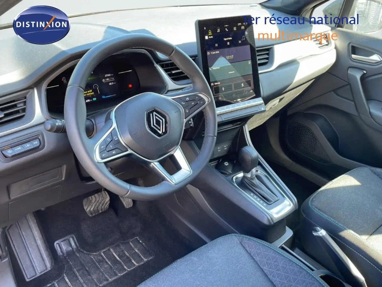 Vue intérieure côté conducteur du Renault Captur E-Tech noir étoile métal 2025, avec volant cuir multifonction et écran tactile vertical.