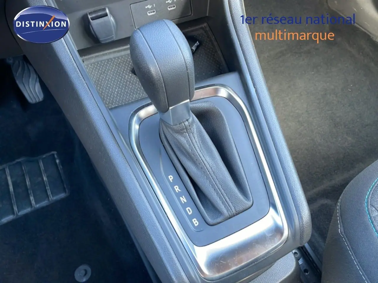 Le levier de vitesse automatique en cuir noir du Renault Captur E-Tech, vu en gros plan depuis le côté passager.