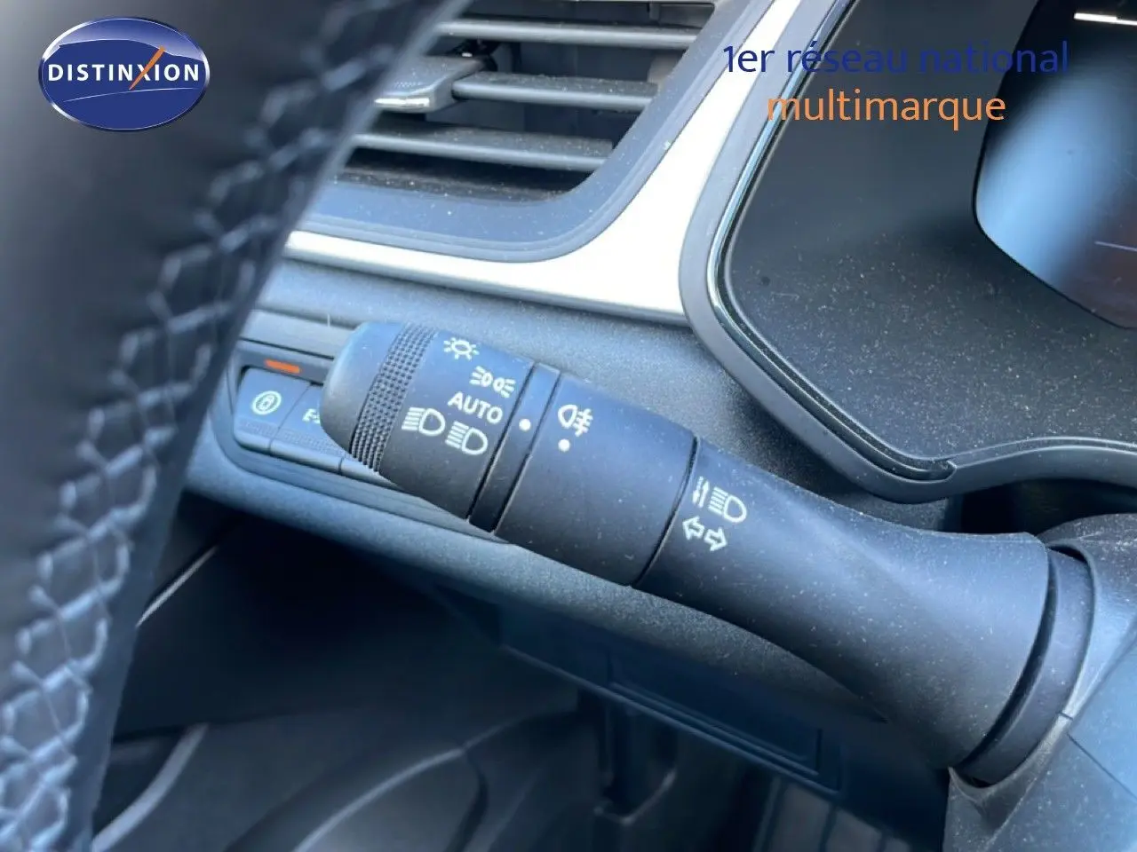 Gros plan sur la commande des feux et clignotants à gauche du volant du Renault Captur noir étoile métal, intérieur moderne.