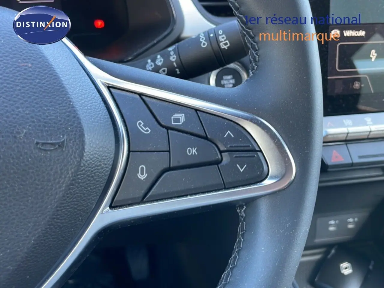 Gros plan sur les commandes au volant côté droit du Renault Captur noir étoile métal, avec tableau de bord numérique en arrière-plan.