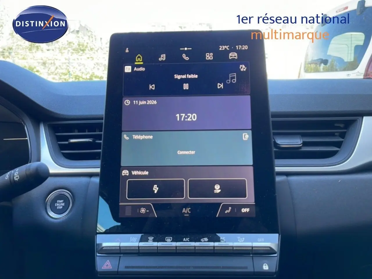 Vue intérieure centrée sur l'écran tactile du tableau de bord du Renault Captur noir étoile métal, avec bouton start visible à gauche.