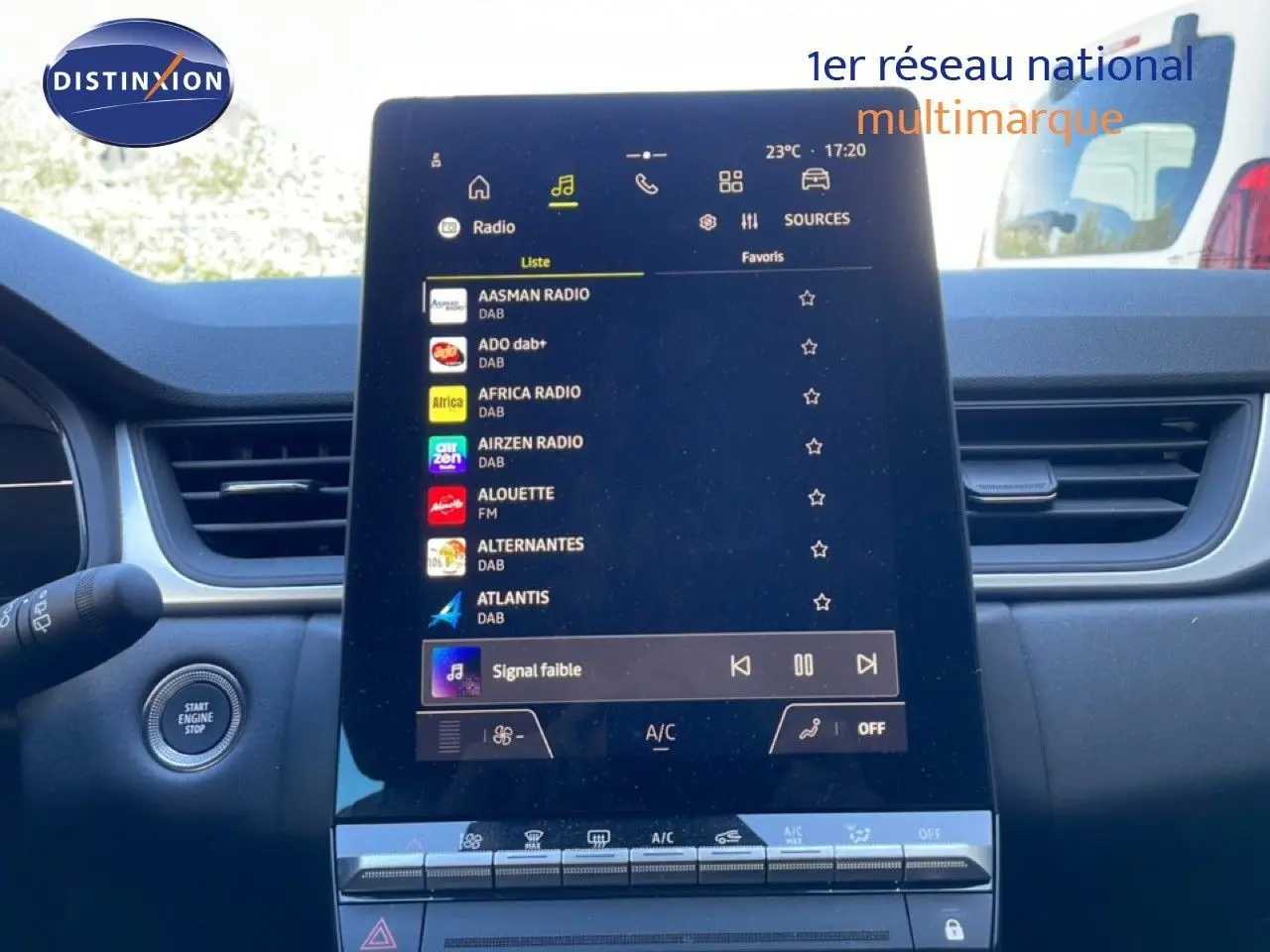 Vue intérieure centrée sur l'écran tactile multimédia du Renault Captur E-Tech noir, avec commandes de climatisation visibles.