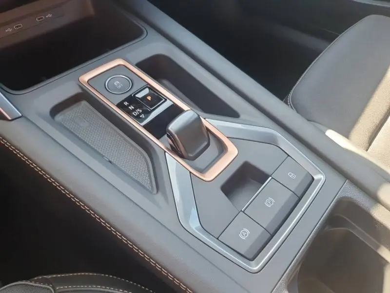 Vue rapprochée de la console centrale du CUPRA Formentor bleu, avec levier de vitesse automatique et finitions cuivrées.