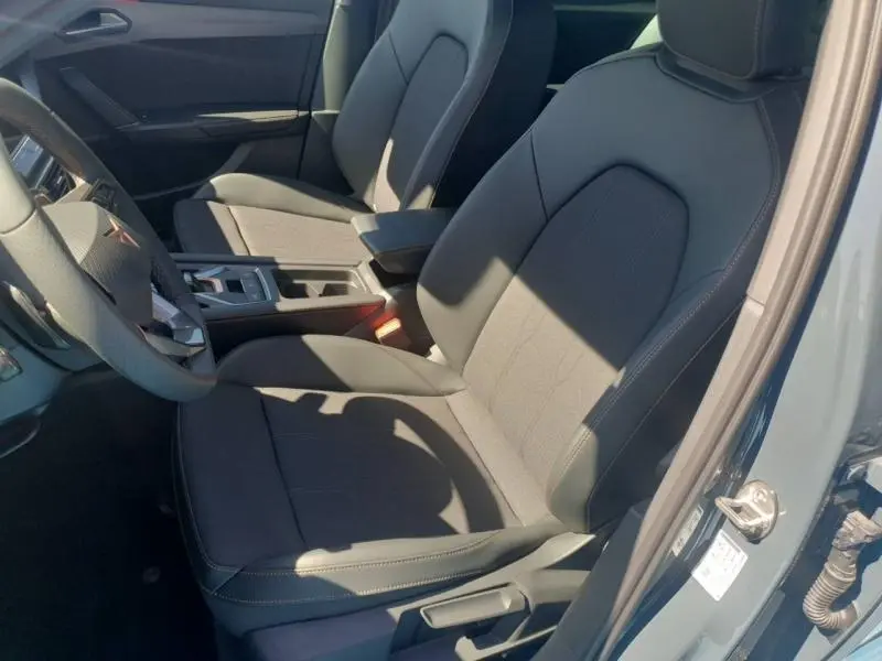 Vue intérieure côté conducteur du CUPRA Formentor 1.5 eTSI Hybrid 2026 avec sièges sport en textile noir et accoudoir central.