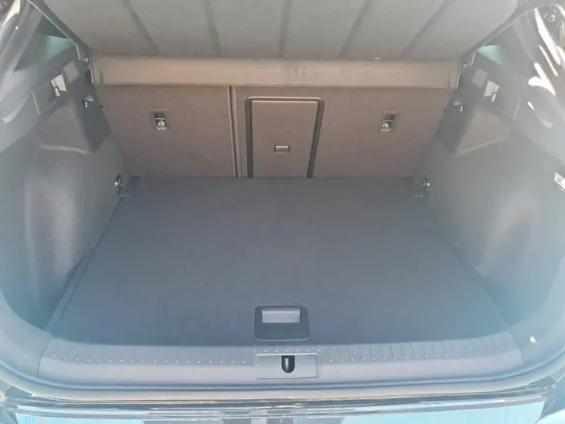 Coffre ouvert vu de l'arrière du CUPRA Formentor bleu, montrant un espace de chargement propre et spacieux.