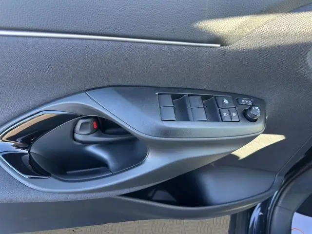 Poignée intérieure et commandes des vitres côté conducteur de la Toyota Yaris Cross 130H Design noire 2025 en gros plan.