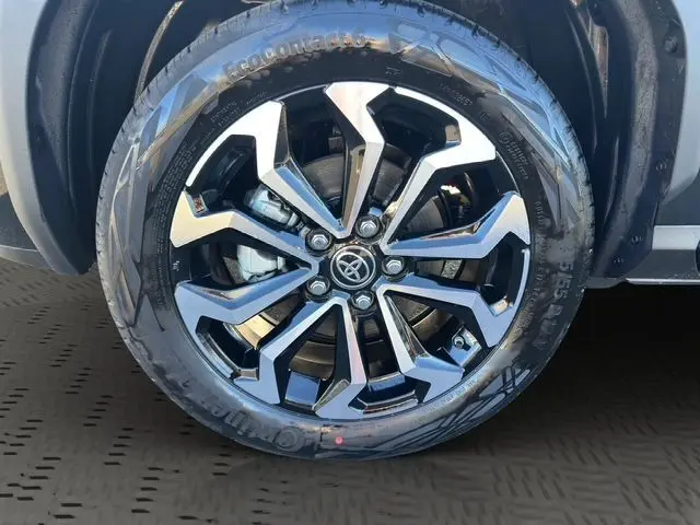 Gros plan sur la jante alliage noire et argentée du Toyota Yaris Cross 130H Design MY25 noir, roue avant côté gauche.