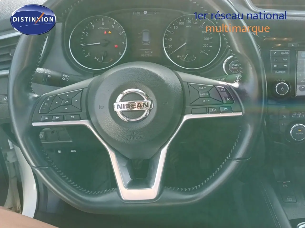 Vue rapprochée du volant noir du Nissan Qashqai blanc 2018 avec tableau de bord et commandes visibles.