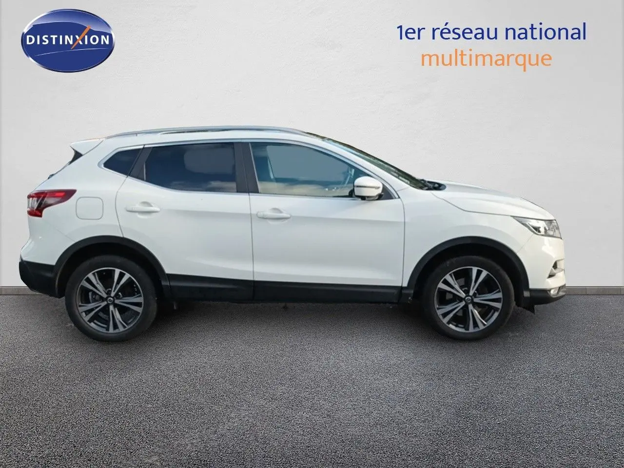Vue de profil côté gauche d'un Nissan Qashqai blanc 2018 avec jantes alliage bi-ton et vitres teintées.