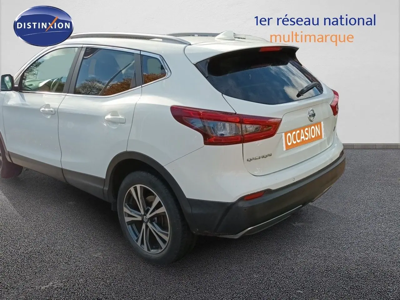 Vue 3/4 arrière droite d'un Nissan Qashqai blanc 2018 avec jantes alliage bi-ton et vitres teintées.