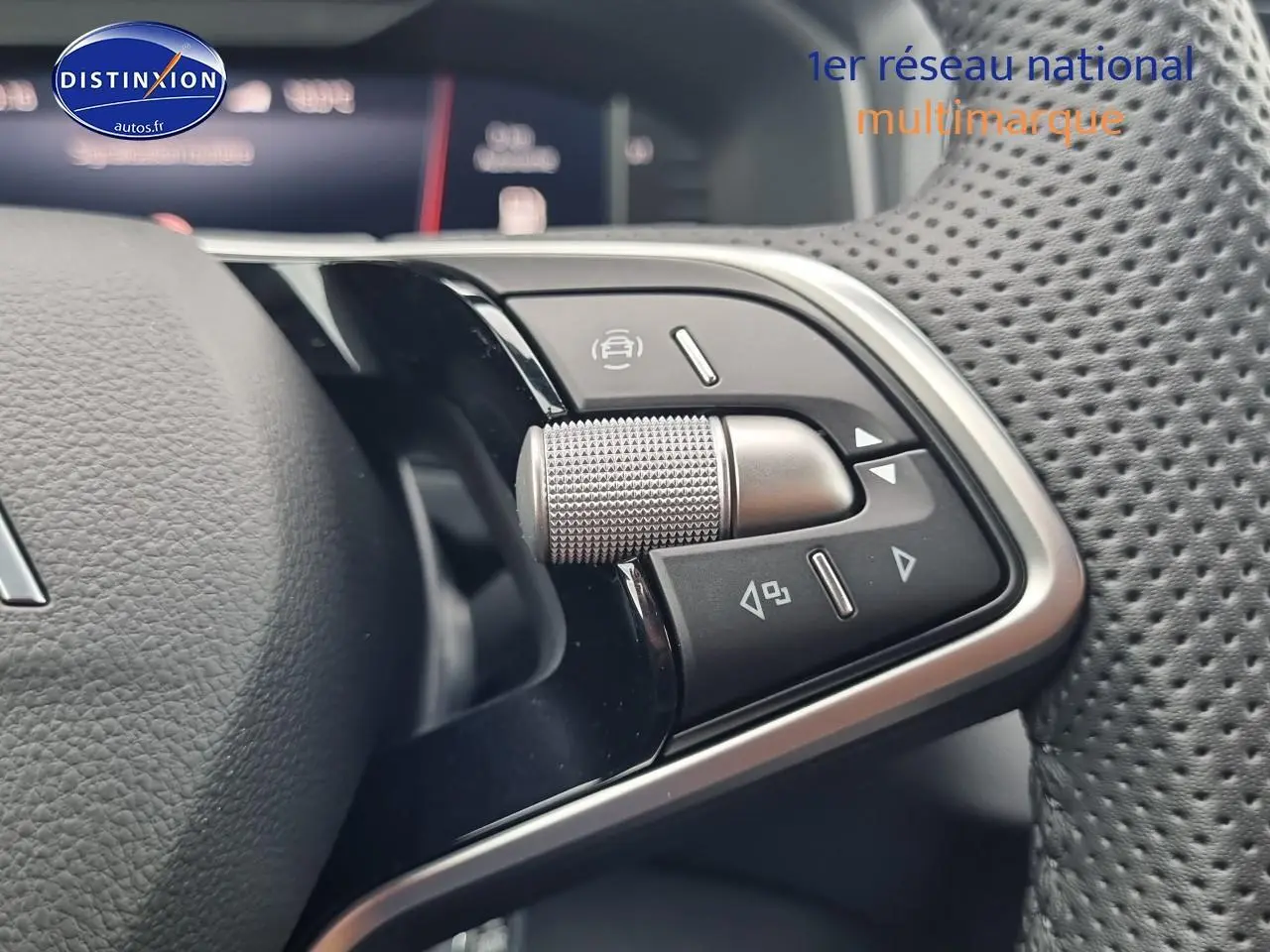 Gros plan sur les commandes multifonctions en aluminium du volant cuir perforé d'un Skoda Karoq noir 2025.