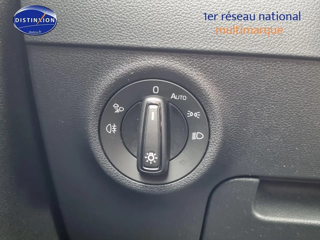 Gros plan sur la molette de commande des phares du Skoda Karoq noir, avec options d'éclairage visibles.