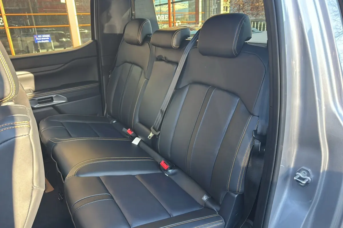 Vue intérieure sur la banquette arrière en cuir noir avec surpiqûres jaunes du Ford Ranger 2025 gris iconic, porte ouverte côté droit.